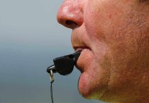 Close up of a sports coach blowing a whistle