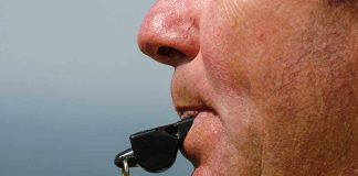 Close up of a sports coach blowing a whistle