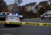 Sheriff line tape blocking scene with police and ambulance.
