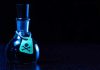 Dark bottle with skull-and-crossbones label on table.