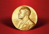 Gold Nobel Prize medal on red background