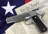 A handgun placed on top of the U.S. Constitution and an American flag
