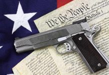 A handgun placed on top of the U.S. Constitution and an American flag