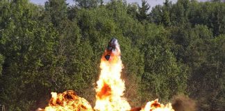 A large explosion with flames and smoke in an outdoor setting