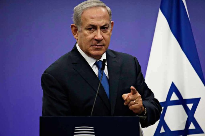 Man in suit giving speech in front of Israeli flag.