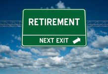 Green road sign reading retirement next exit sky background