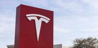 Tesla sign in front of dealership.