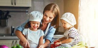 Family cooking together with vegetables in kitchen