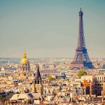 A panoramic view of Paris featuring the Eiffel Tower and a golden dome