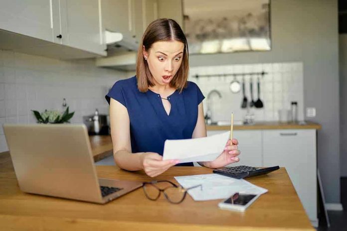 Woman shocked reading a document at home.