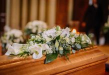 Flower arrangement on a wooden casket at a funeral