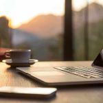 Laptop coffee cup and phone on wooden table