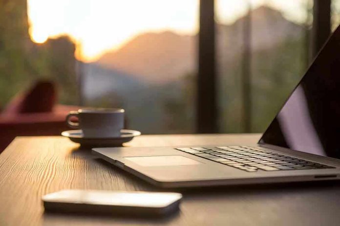 350692013 Laptop coffee cup and phone on wooden table